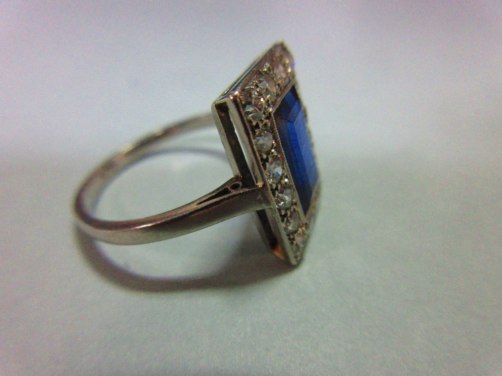 A mid 20th century sapphire and diamond ring, the rectangular step cut royal blue sapphire in a - Image 2 of 6