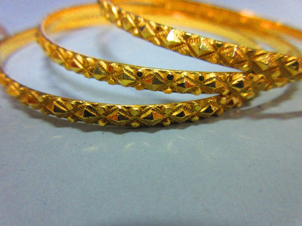 A collection of gold slave bangles, three of hallmarked 22ct gold with faceted diaper patterning, - Image 2 of 5