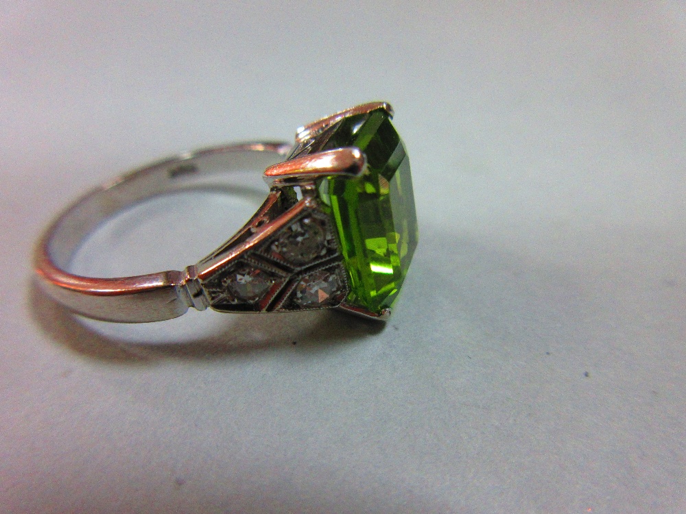A 1930s style peridot and diamond ring, the emerald cut peridot measuring 10.6 x 8.7mm, four claw - Image 5 of 5