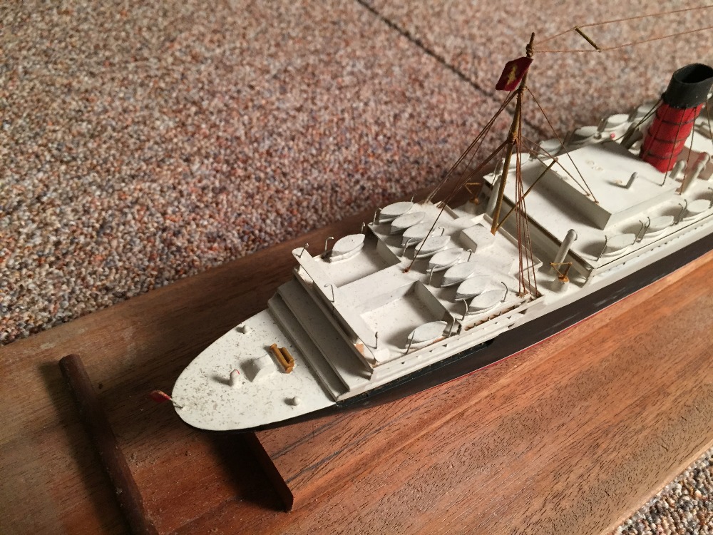 A mid 20th century painted wood model of a four-funnel passenger ship, mounted within a glazed - Image 4 of 4