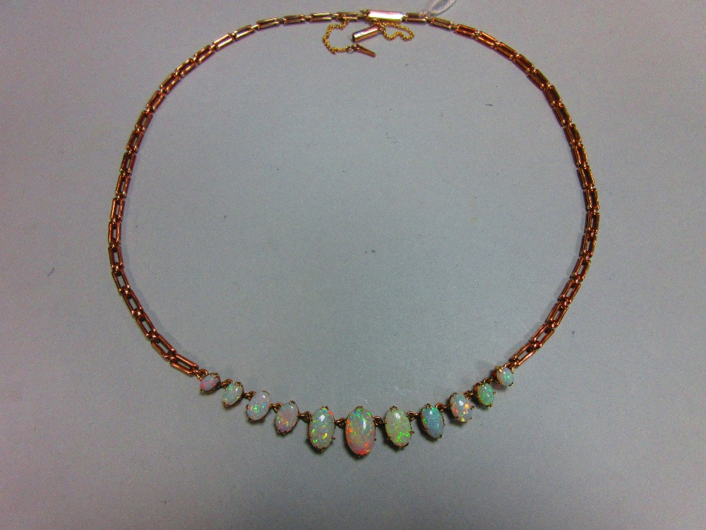 A graduated opal necklace, set to the front with an articulated line of eleven oval cabochon opals