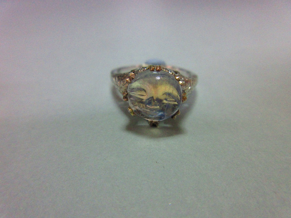 A 'man in the moon' carved moonstone ring, the circular low cabochon stone carved with the smiling - Image 2 of 8