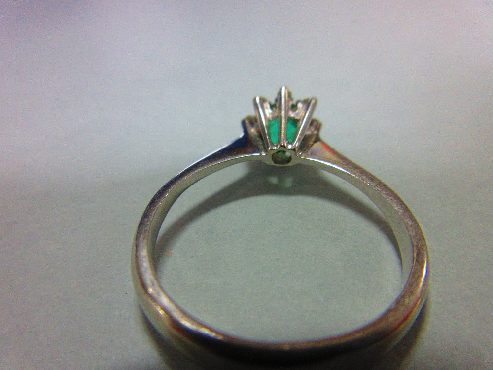 An emerald and diamond ring, set with a round cut emerald in a small petal border of eight single - Image 4 of 4