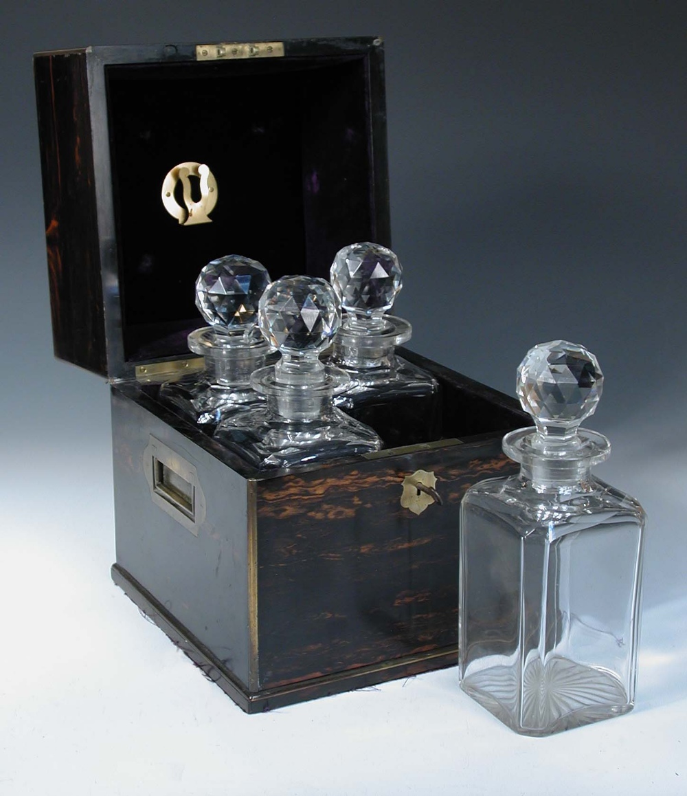 A 19th century calamander decanter box, the rising top opening to reveal four period cut glass