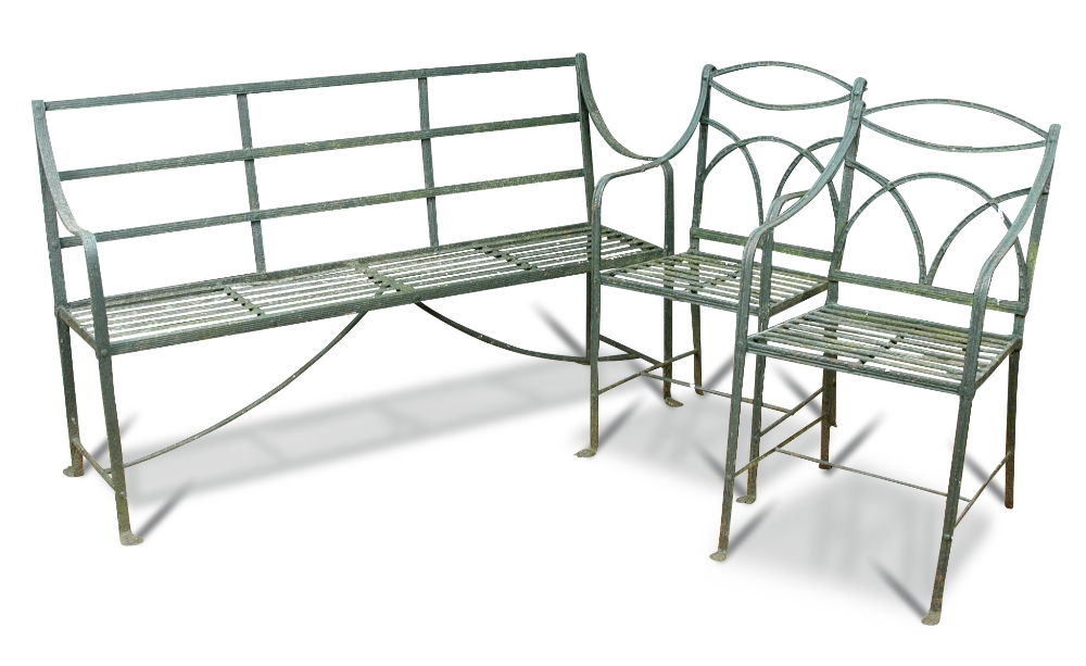 A Regency wrought iron strapwork garden seat, painted green and two similar strapwork chairs on