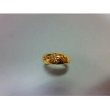 An Edwardian 18ct gold and diamond ring, set with an old round brilliant diamond between two smaller