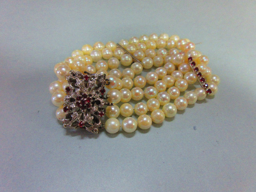 A four row pearl bracelet with feature clasp, the uniform 6.5mm pearls (one strand broken, one loose