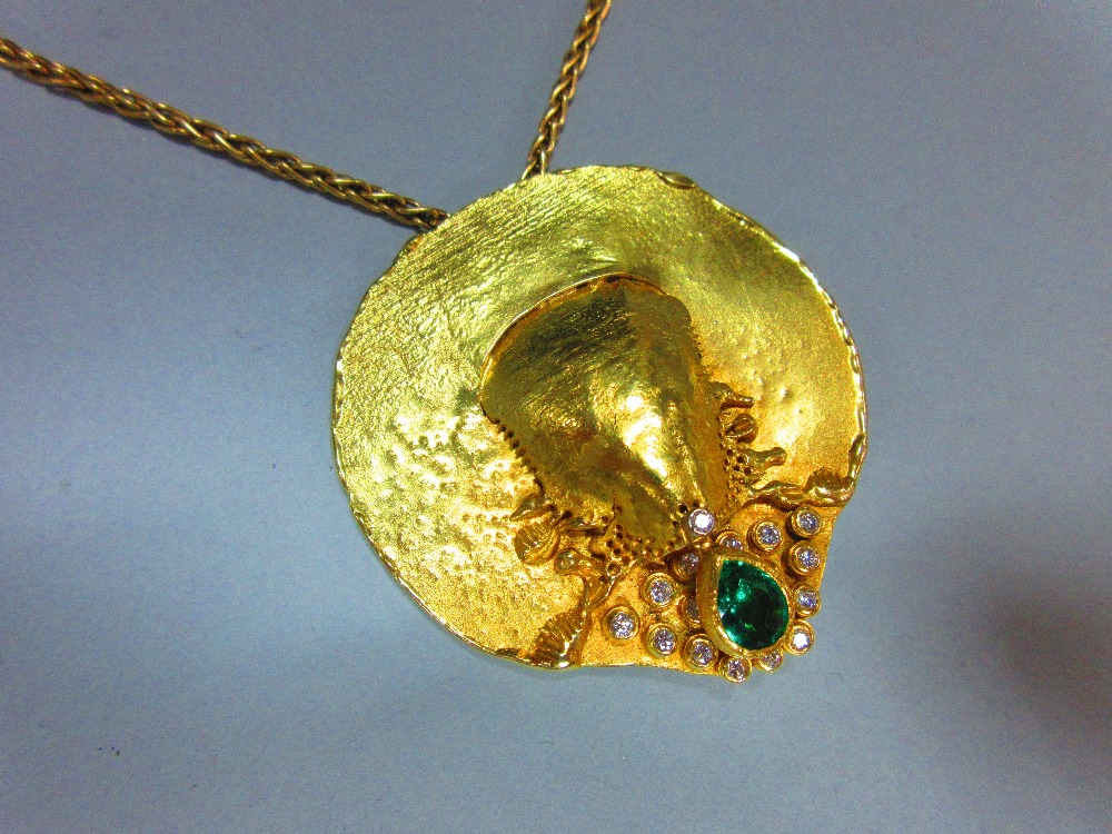 A contemporary emerald and diamond set disc pendant and 18ct gold chain, the variably textured and