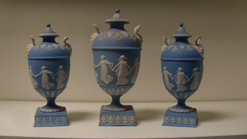 A garniture of three Wedgwood blue jasper vases and covers, each of the ovoid bodies sprigged with