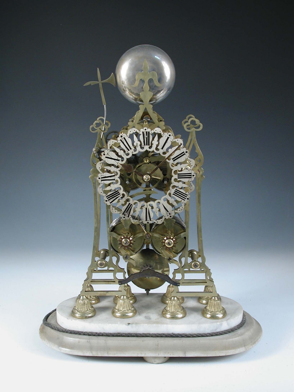 A Victorian brass skeleton clock, the spire top case with bell above pierced silvered chapter ring