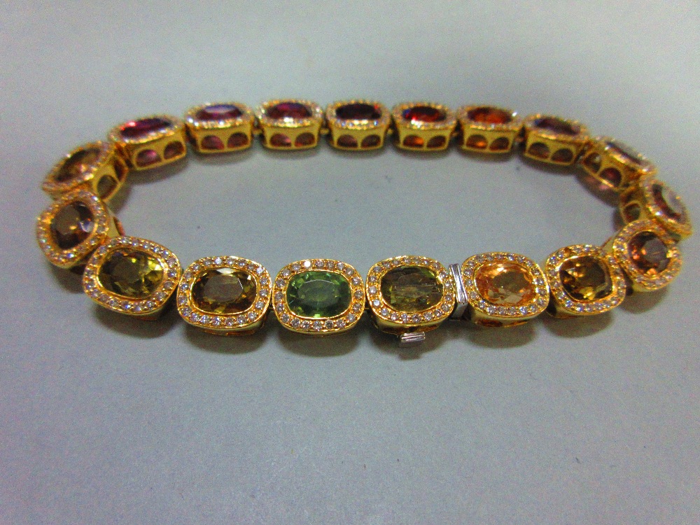A multi gem set and diamond bracelet, each of the eighteen oval cut stones set in a border of