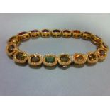 A multi gem set and diamond bracelet, each of the eighteen oval cut stones set in a border of