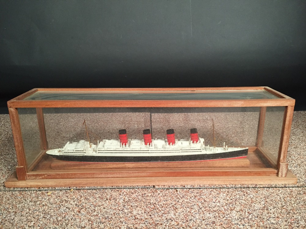 A mid 20th century painted wood model of a four-funnel passenger ship, mounted within a glazed