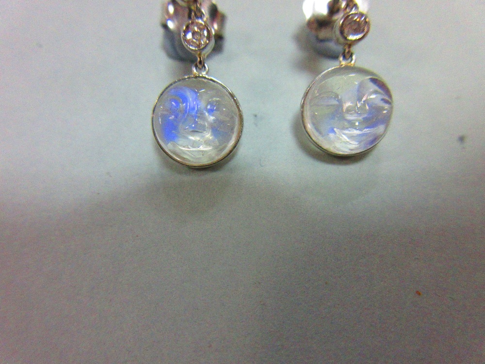A pair of 'man in the moon' carved moonstone and diamond earpendants, designed as an articulated - Image 2 of 5