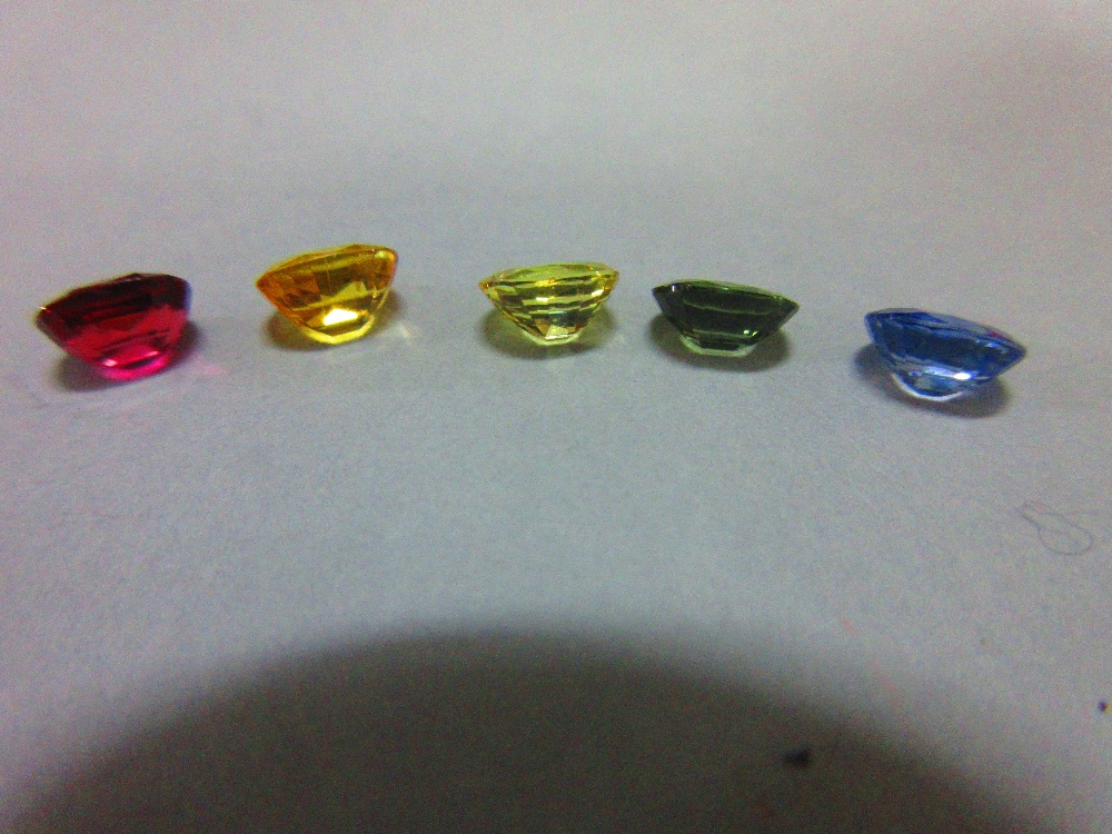 A loose ruby and four loose variously coloured sapphires, all oval to rectangular cushion cut and - Image 2 of 5