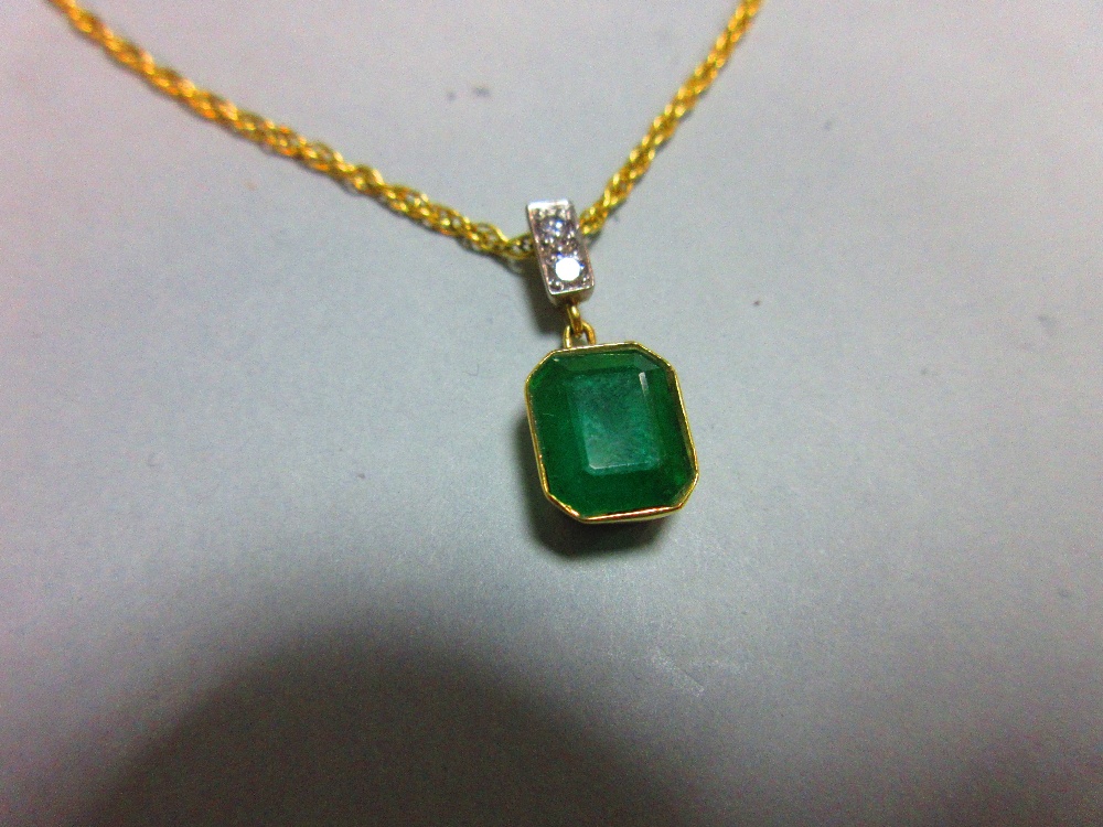 An emerald and diamond pendant set in 18ct gold, with chain, the emerald cut emerald collet set - Image 3 of 5