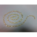 A moonstone necklace, designed as a chain of graduated spectacle set cabochon moonstones joined by