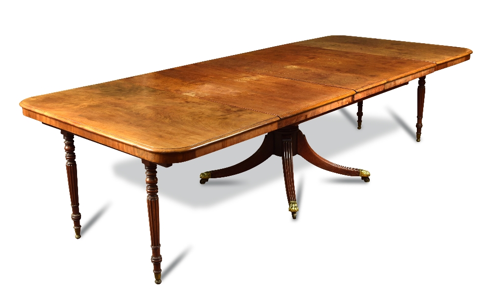 A Regency mahogany extending pedestal dining table, with folding gadroon moulded legs, supporting