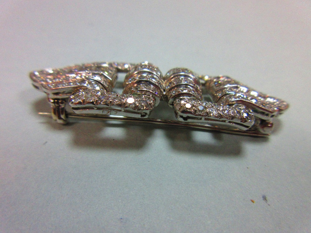 A French art deco odeonesque diamond and platinum brooch, of pierced double buckle form, with a - Image 2 of 6