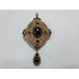 A gold and garnet Holbeinesque pendant / brooch, of oval tiered form, set to the cardinal points
