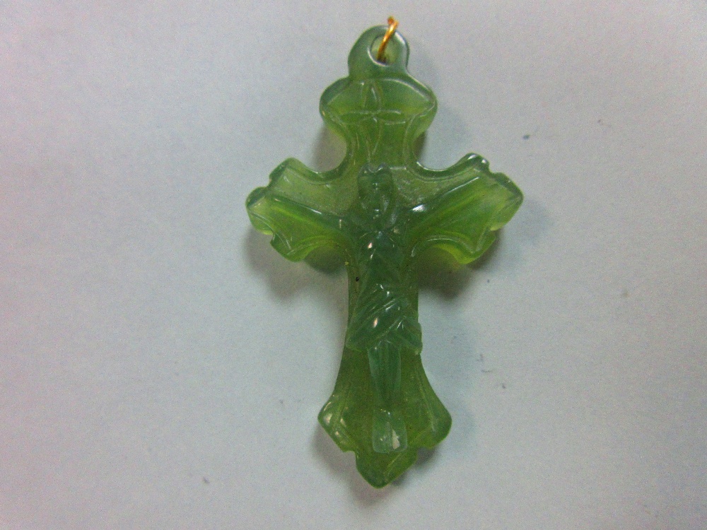 A carved green hardstone crucifix pendant, the treflee form cross with incised edge decoration and