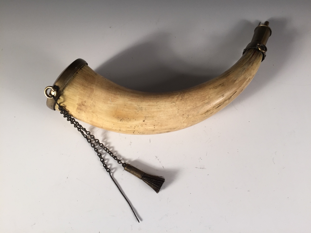 A late 18th or early 19th century powder horn, brass mounted, one end engraved with the crest of the