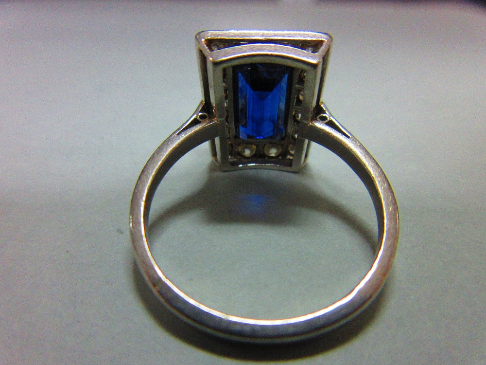 A mid 20th century sapphire and diamond ring, the rectangular step cut royal blue sapphire in a - Image 4 of 6