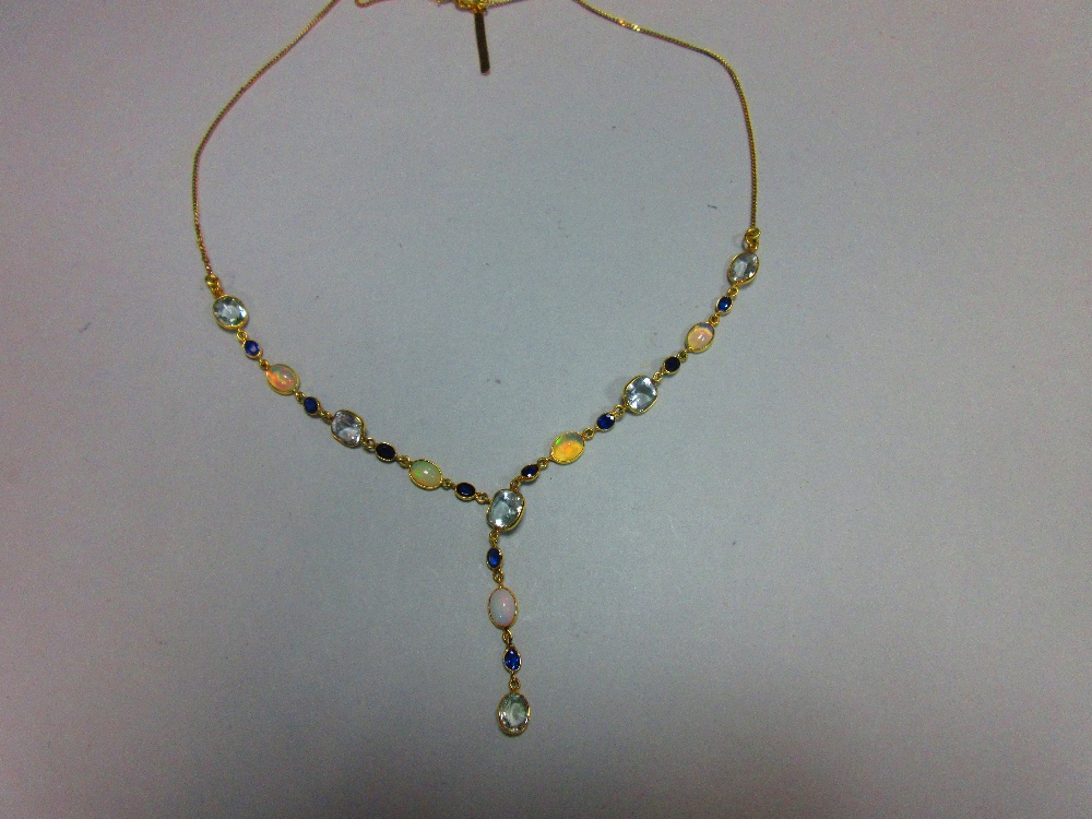 An 18ct gold opal, sapphire and aquamarine necklace, set to the front with an articulated line of