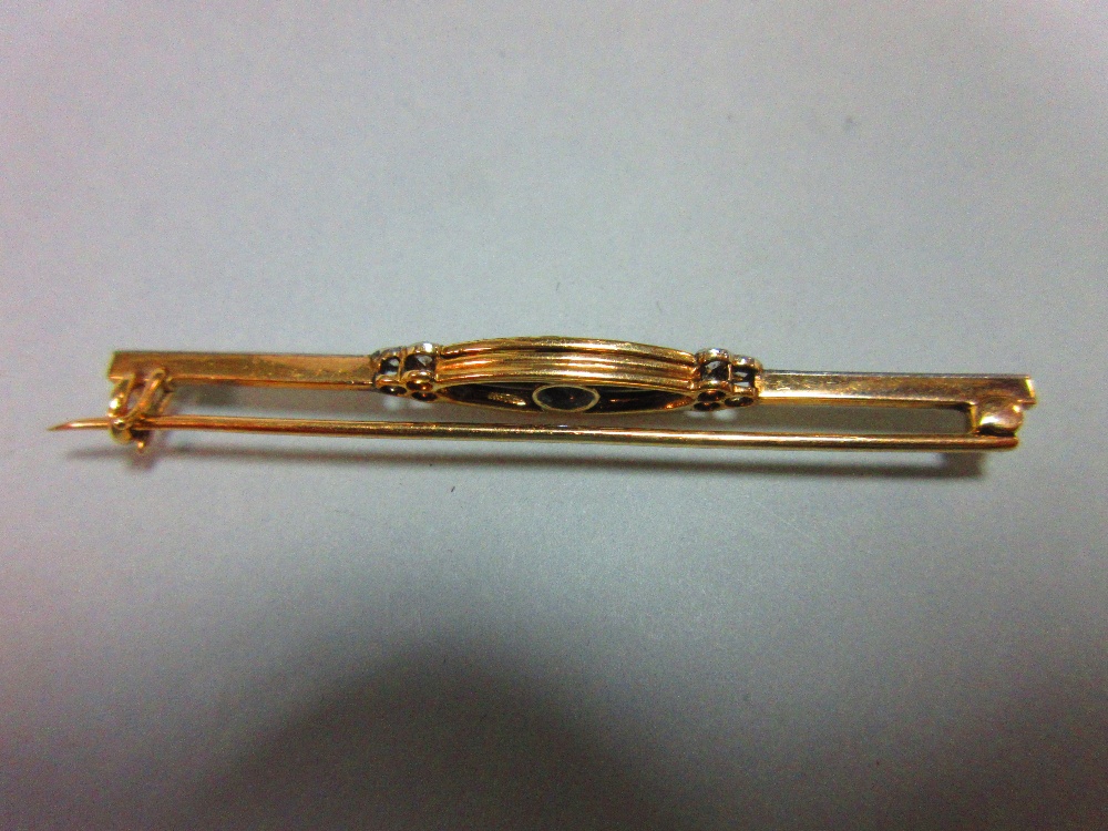 A diamond and enamel bar brooch, set to the centre with a graduated line of five old round brilliant - Image 2 of 4