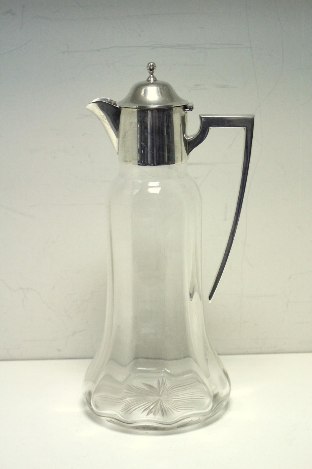 A plain glass claret jug with silver mount, by William Hutton & Sons, Birmingham 1919, the bell