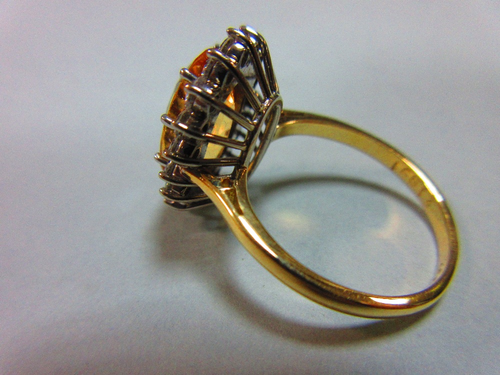 A topaz and diamond cluster ring, the oval mixed cut golden topaz claw set to a border of eighteen - Image 3 of 5