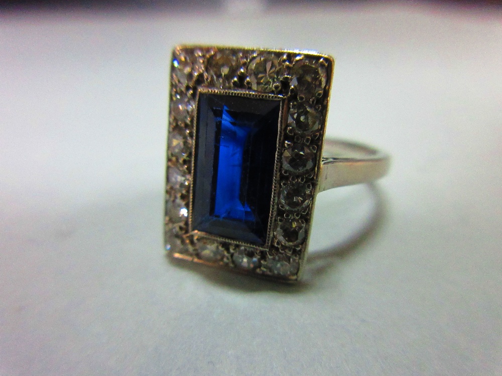 A mid 20th century sapphire and diamond ring, the rectangular step cut royal blue sapphire in a - Image 6 of 6