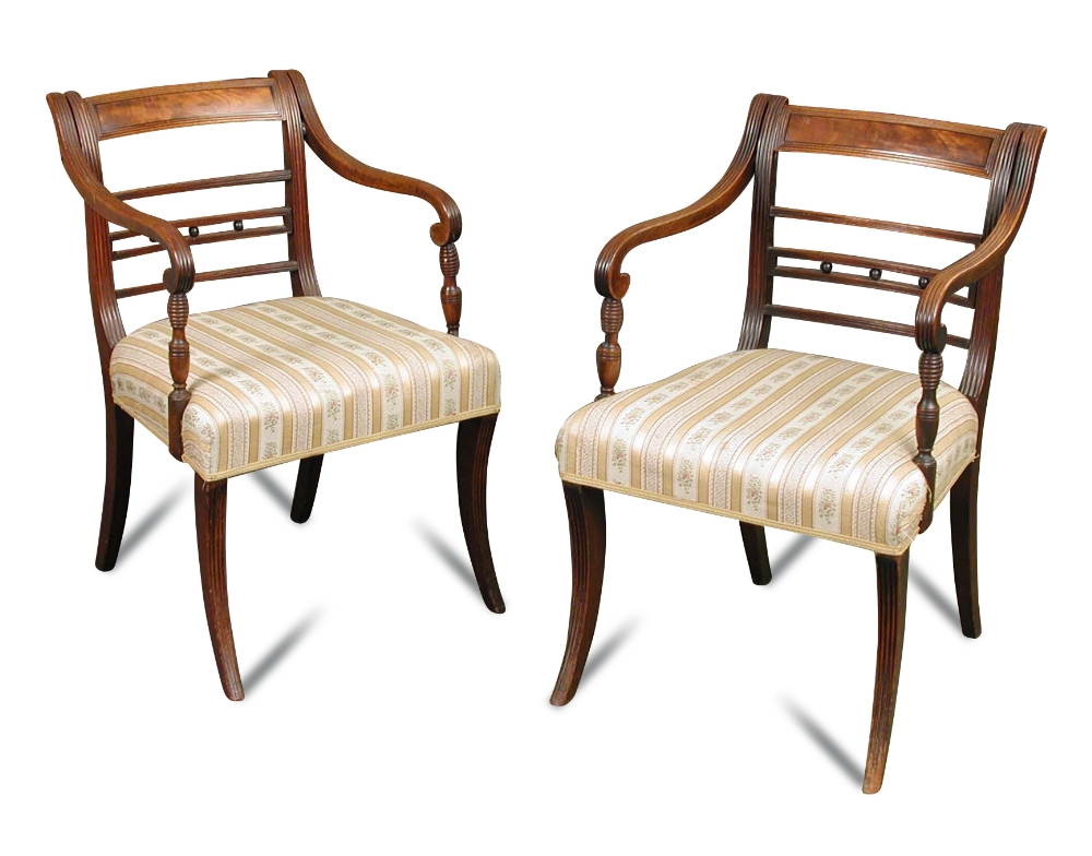 A Pair Regency mahogany bar back elbow dining chairs, with ebony line inlays, the reeded arms on