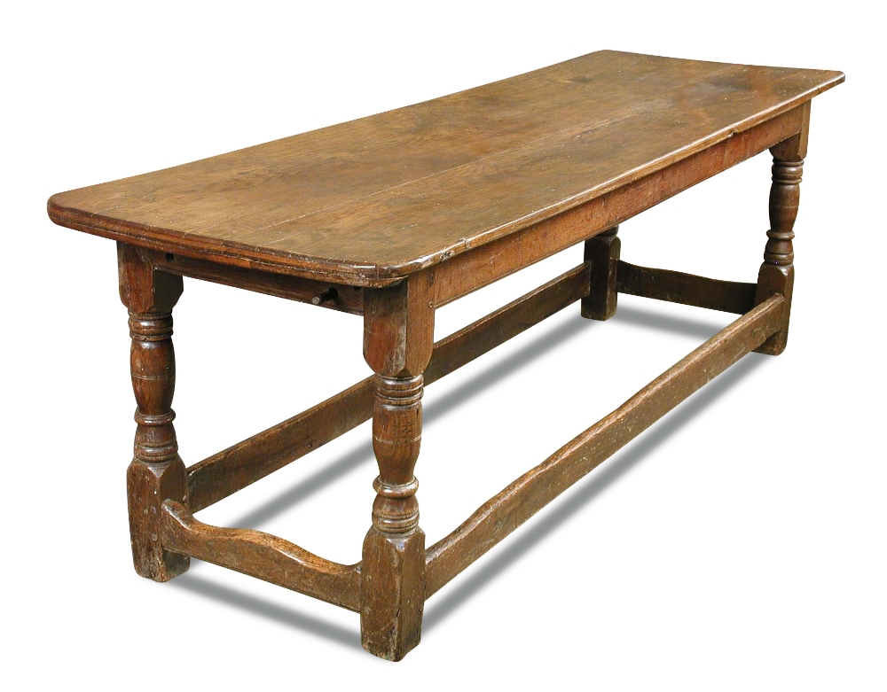 A 17th century oak refectory table, with a plank top on turned baluster column legs, united by