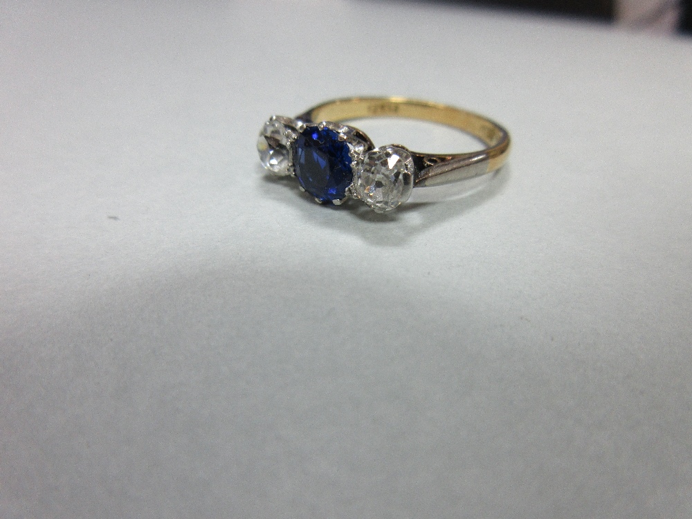 A three stone sapphire and diamond ring, claw set with a round cut royal blue sapphire between old - Image 2 of 7