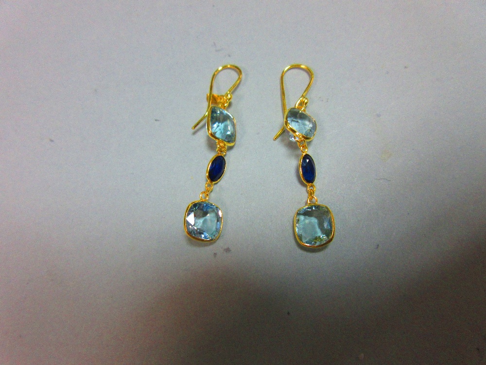 A pair of aquamarine and sapphire earrings, each gold wire hook suspending an articulated line of