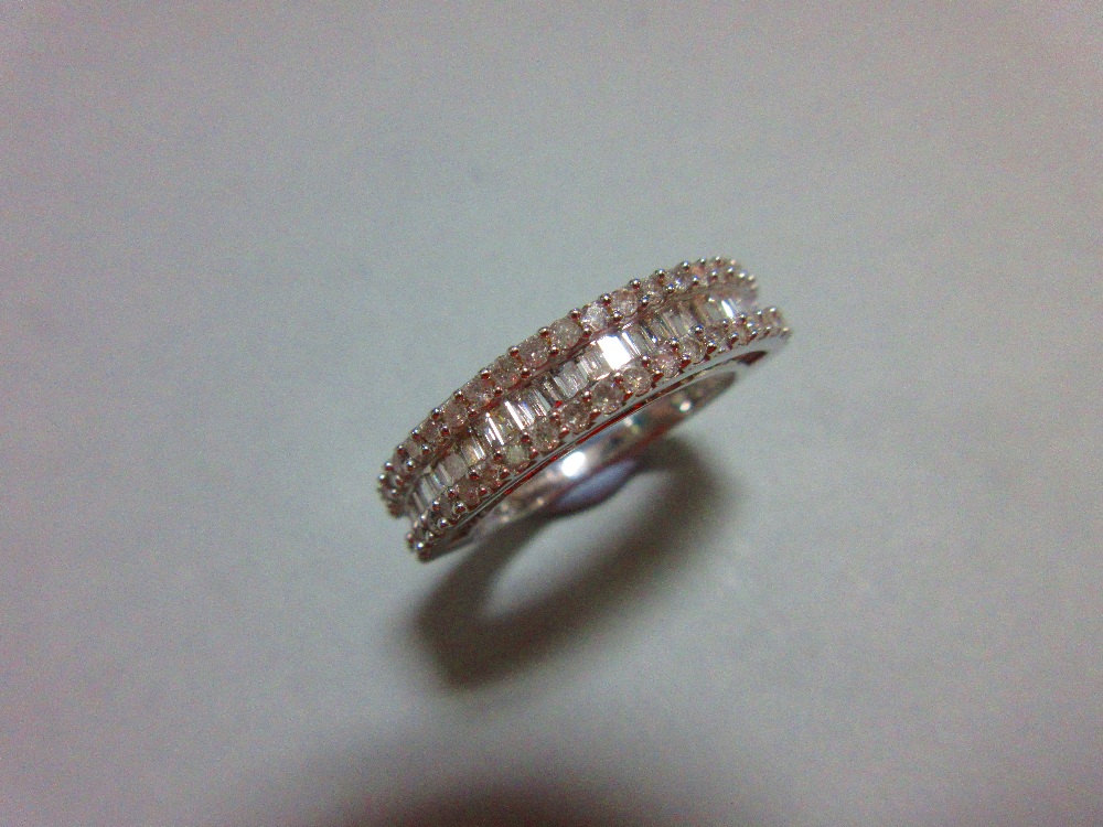 A white gold and diamond half hoop ring, with a channel set line of baguette cut diamonds between