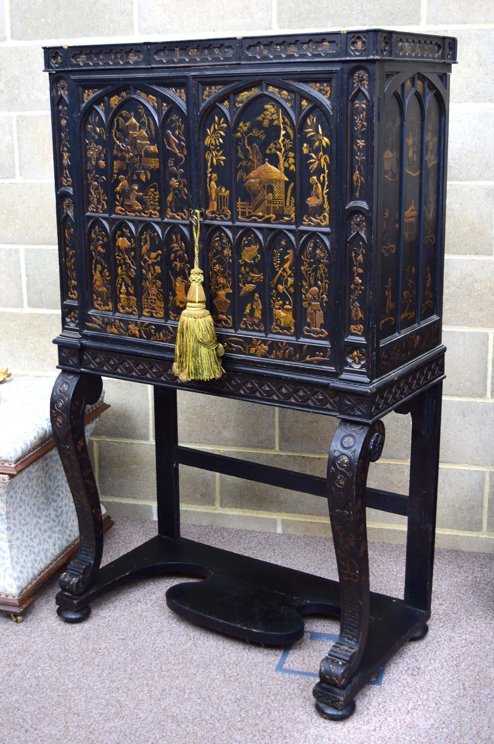 A Regency gothic revival black lacquer cabinet on stand, decorated in gilt with Chinoiseries in