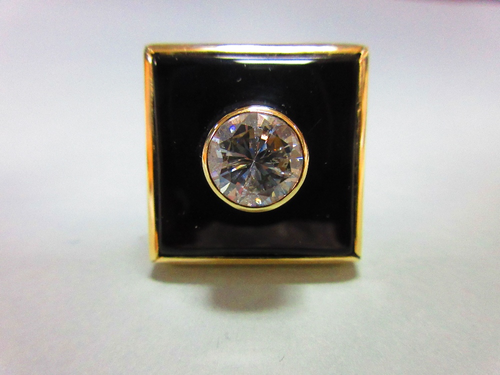 A 2ct diamond, onyx and gold modern handmade designer ring, the round brilliant cut diamond collet