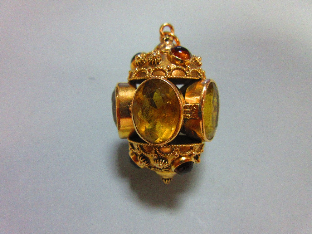 An ornate citrine set pendant, designed as five oval cut and collet set lemon citrines forming a