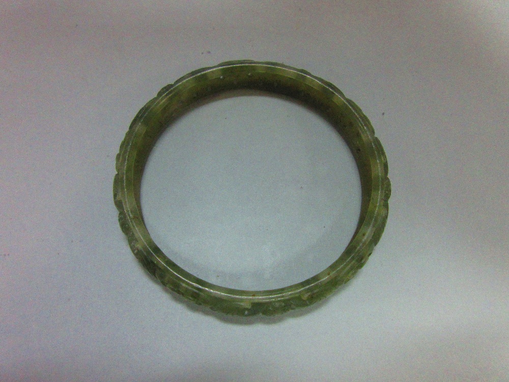 A carved jade bangle, the mottled light green jade of convex profile, pierced and carved with - Image 4 of 5