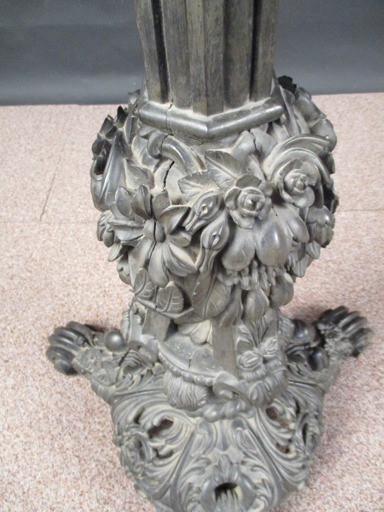 An early 19th century Indian ebony pedestal, profusely carved with leaves, flowers and figure heads, - Image 3 of 3