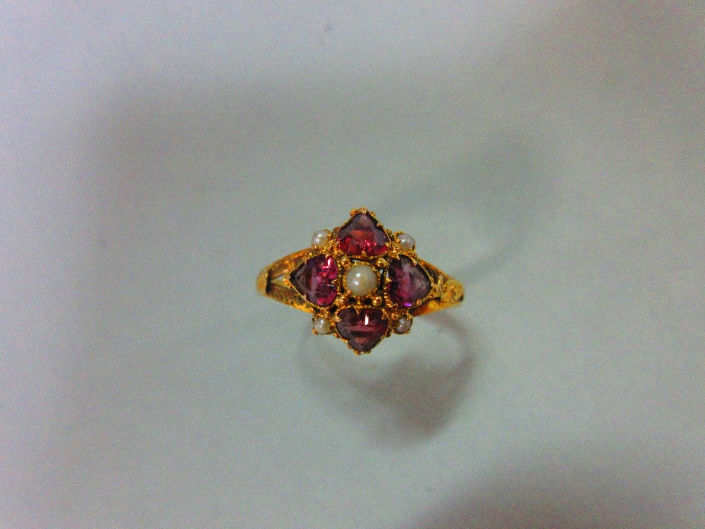 A mid Victorian 15ct gold, garnet and seed pearl quatrefoil ring, with four heart cut almandine