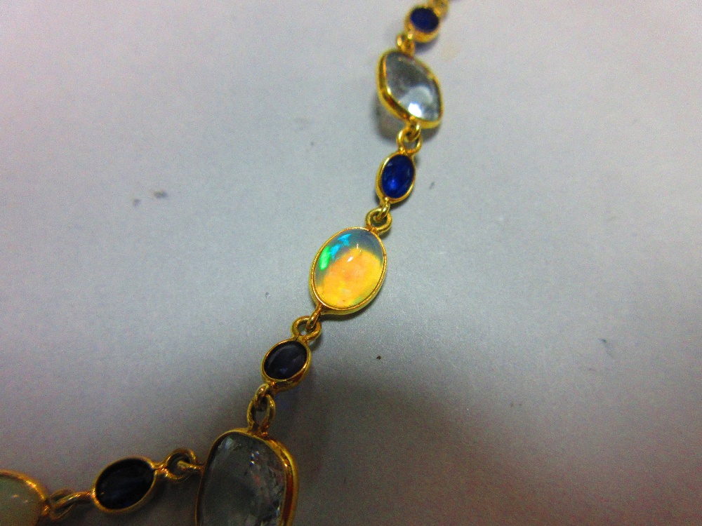 An 18ct gold opal, sapphire and aquamarine necklace, set to the front with an articulated line of - Image 3 of 4