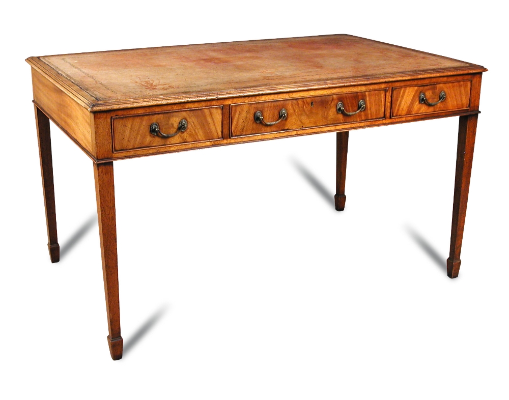 A George III style mahogany library table, with faded red leather lined top, fitted three frieze