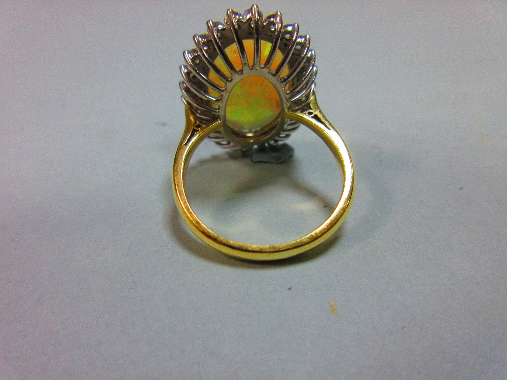 An opal and diamond cluster ring, the 17mm long oval cabochon opal, displaying good predominantly - Image 4 of 4