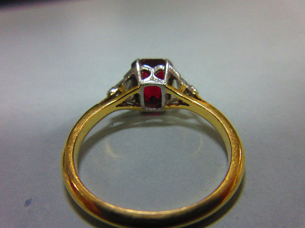 A ruby and diamond three stone ring, the emerald cut ruby four claw set between two trilliant cut - Image 4 of 4