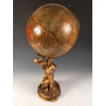 A Geographia 10 inch terrestial globe, early 20th century, supported on a gilt metal figure of Atlas