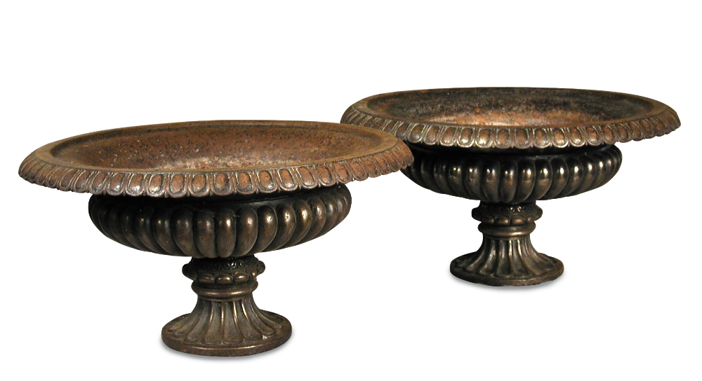 A pair of Regency style cast iron urns, with cast egg and dart rims to fluted spreading circular