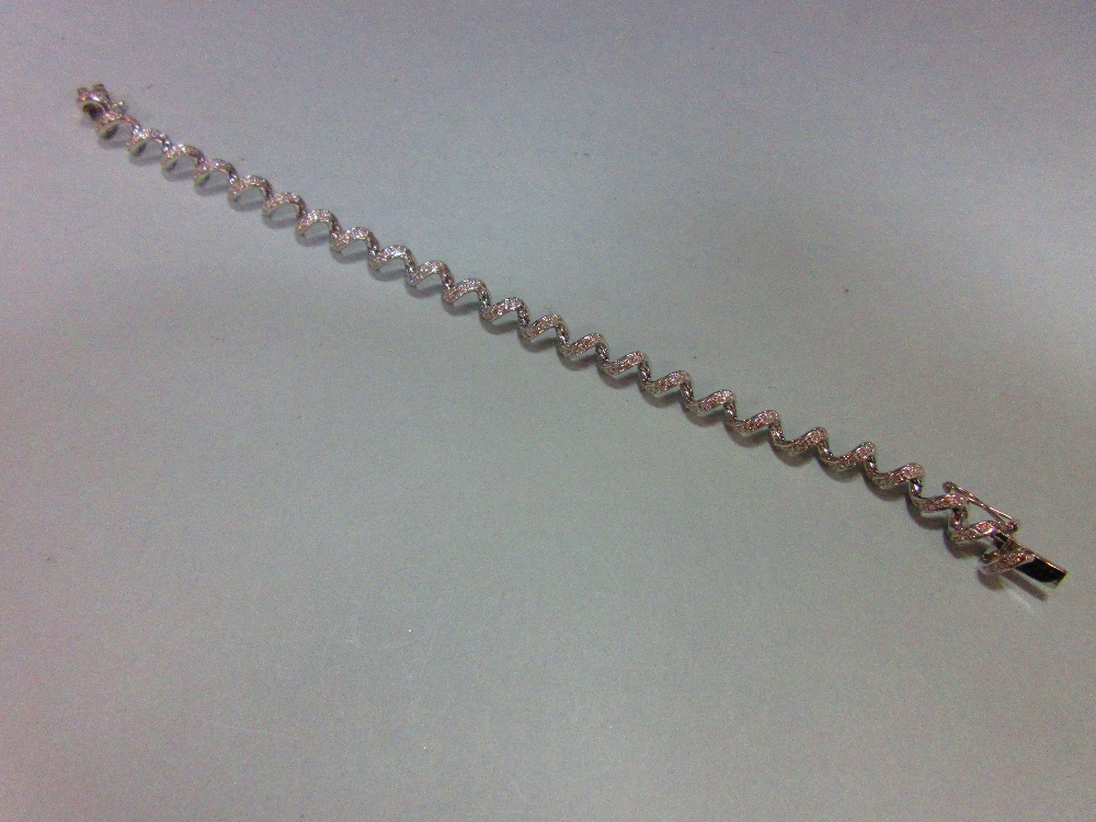 A spiral link diamond bracelet, the continuous smooth line of links forming an open centre